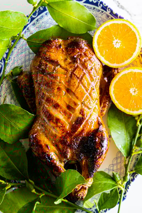 Whole roast duck with crispy golden brown skin and orange honey glaze.