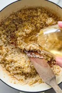 White wine poured into risotto.