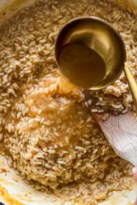 Seafood stock poured into risotto.