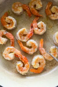 Seared shrimp in pan.