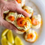 Crispy hashbrown topped with cream cheese and smoked salmon rose appetizer.