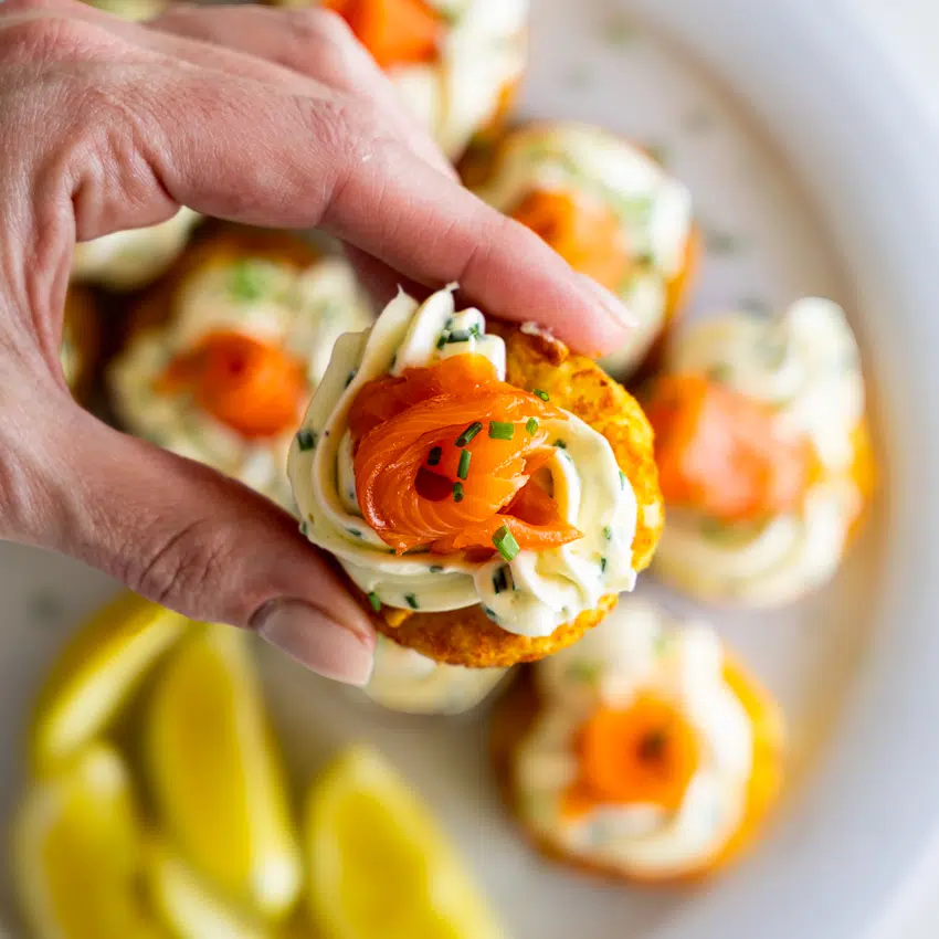 Crispy hashbrown topped with cream cheese and smoked salmon rose appetizer.