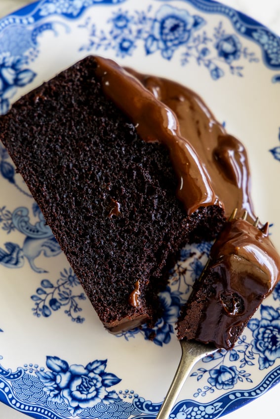 A slice of chocolate pound cake with chocolate ganache.