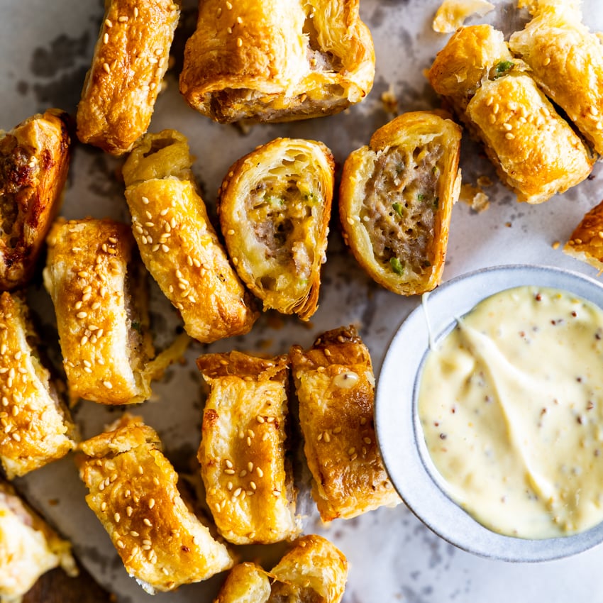 Plate of homemade sausage rolls with dipping sauce.