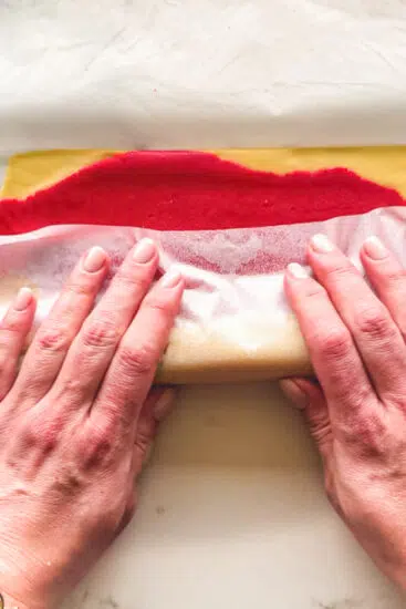 Red and white cookie dough rolled together for pinwheel cookies.