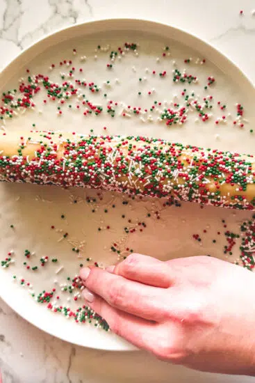 Cookie dough log covered in festive sprinkles