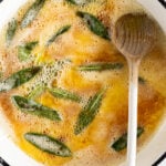 Brown butter sage sauce in a frying pan with wooden spoon.