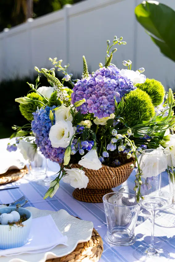 Blue and white floral arrangement in rattan bowl for Easter.