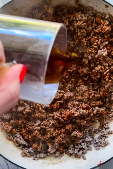 Beef stock poured into taco meat.
