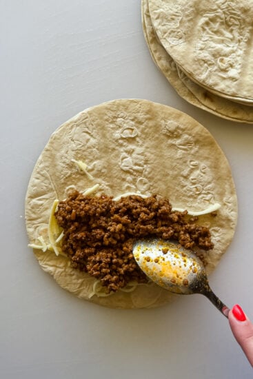Taco meat placed in flour tortillas.