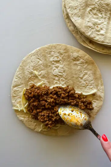 Taco meat placed in flour tortillas.