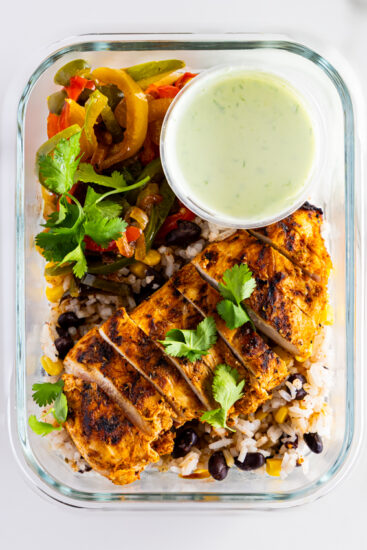 Chicken Fajita Bowls in a meal prep container with crema.