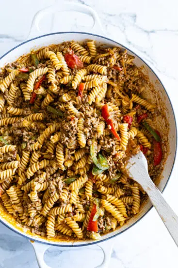 Taco Pasta in a skillet with a wooden spoon.
