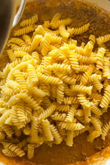Al dente pasta added to taco meat.