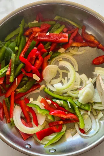 Peppers and onions in frying pan.