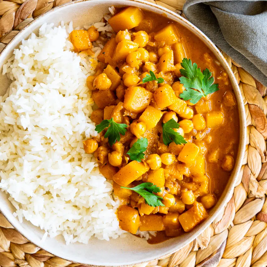 Creamy chickpea butternut squash curry with rice in a serving bowl.