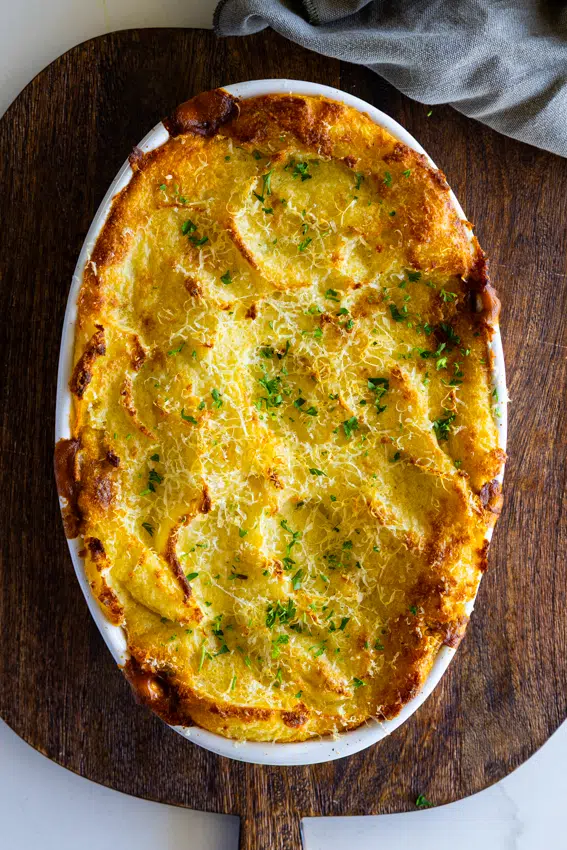 Golden brown Cottage Pie in oval baking dish.