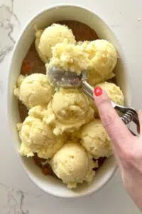 Mashed potatoes added to cottage pie filling.