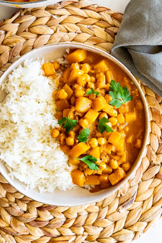 Creamy chickpea butternut squash curry with rice in a serving bowl.