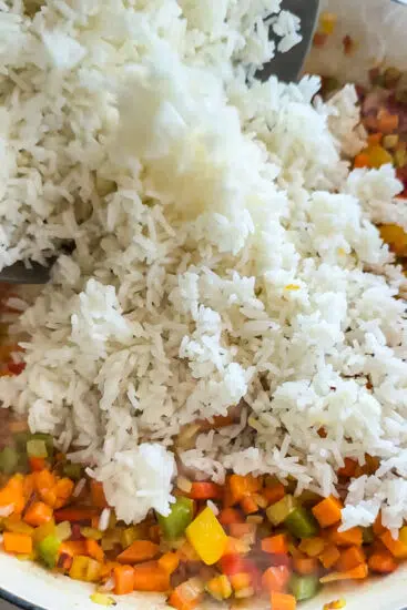 Cold rice added to pan with vegetables.