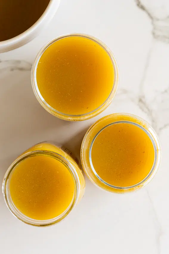 Homemade chicken stock in glass jars.