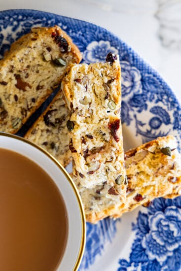 Seed and nut rusks with a cup of tea on a blue and white plate.
