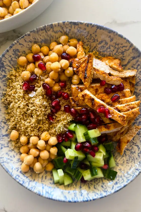 Moroccan Chicken CousCous Bowls with cucumber and pomegranate.