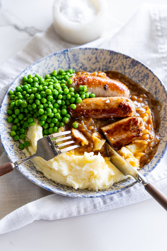 Bangers and mash with onion gravy and peas.