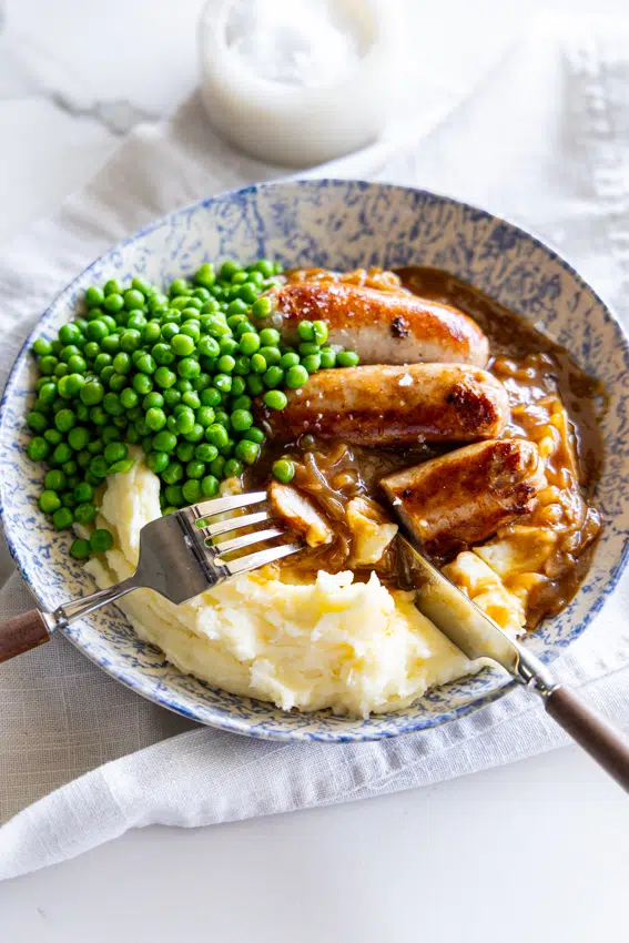 Bangers and mash with onion gravy and peas.