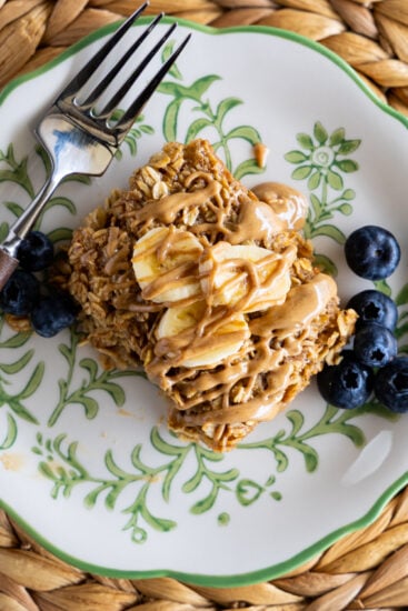Baked oatmeal on serving plate with bananas and blueberries.