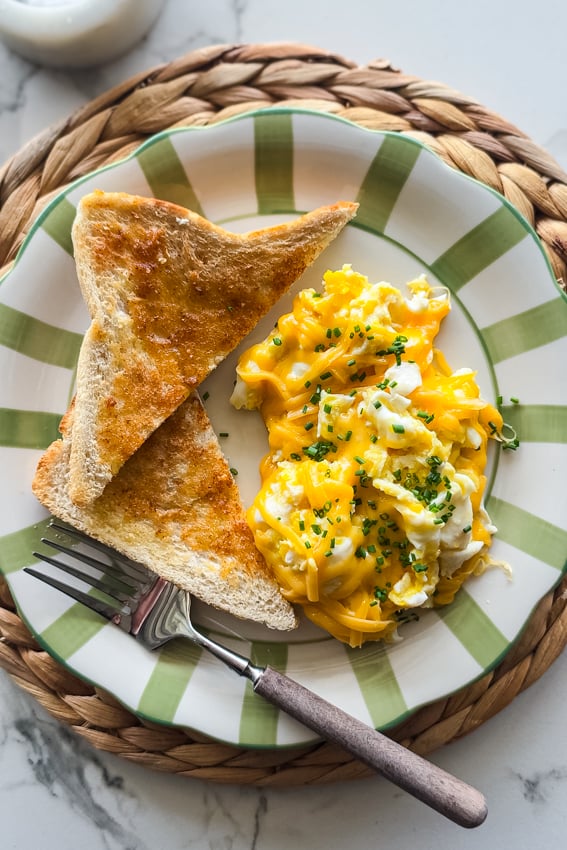 Frambled eggs with toast on serving plate.