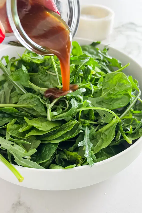 Balsamic Vinaigrette poured over salad greens.