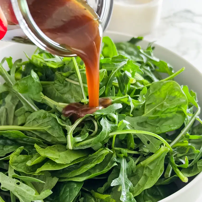 Balsamic vinaigrette poured over mixed salad greens.